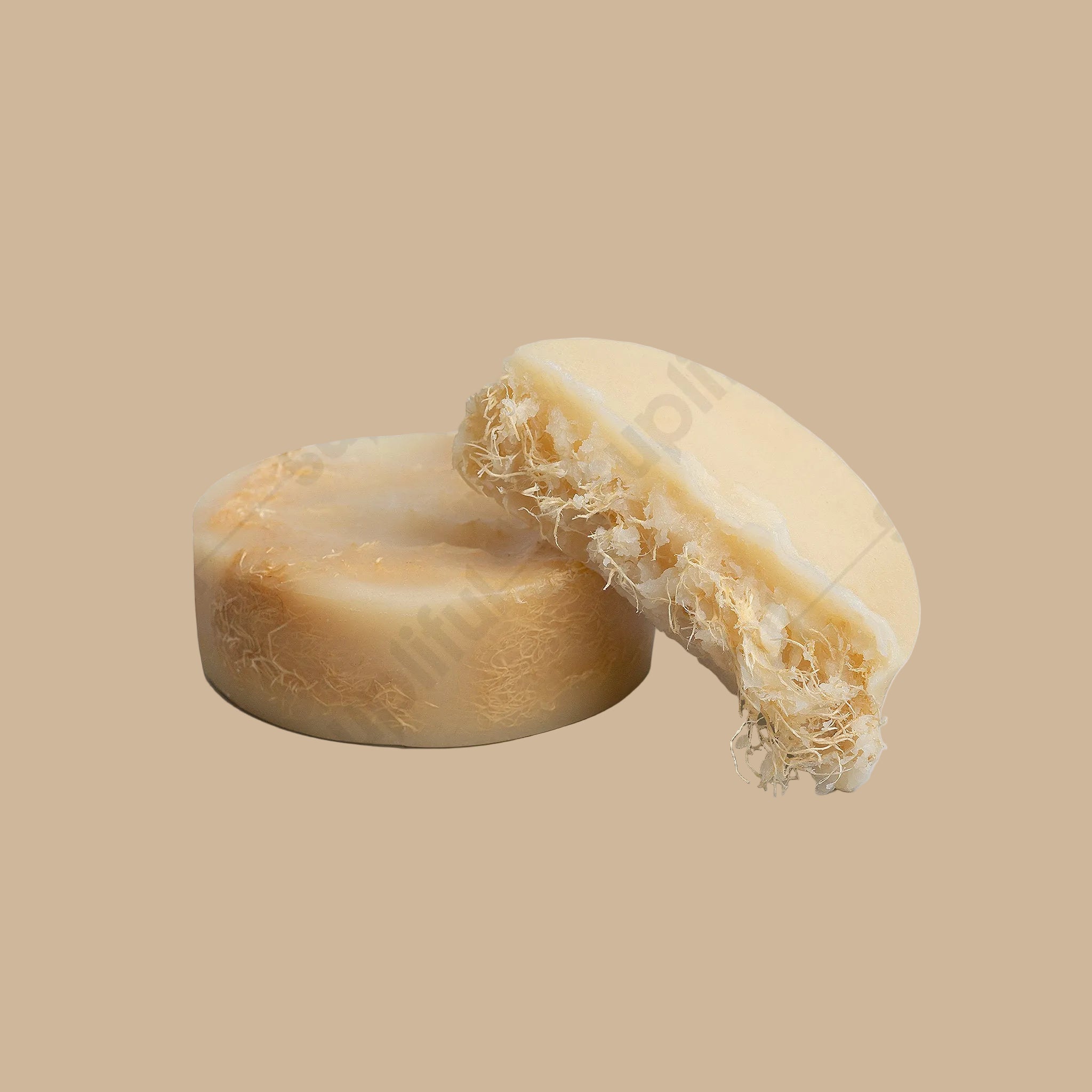 Bar of soap with a soft, porous texture on a light gray background