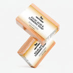 Two bars of Kojic Acid & Turmeric Soap by Nestdeer on a white background.