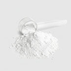 White powder in a clear plastic scoop on a white background