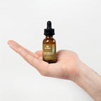 Hand holding a bottle labeled 'Scalp Health & Hair Growth' against a light background