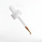 White dropper with brown liquid on a white background