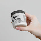 Hand holding a jar of Nestoeer Recovery Cream against a light background