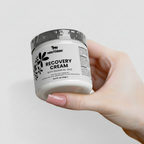 Hand holding a jar of Nestlère Recovery Cream against a light background
