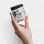 Hand holding a jar of Nestor Recovery Cream against a light background