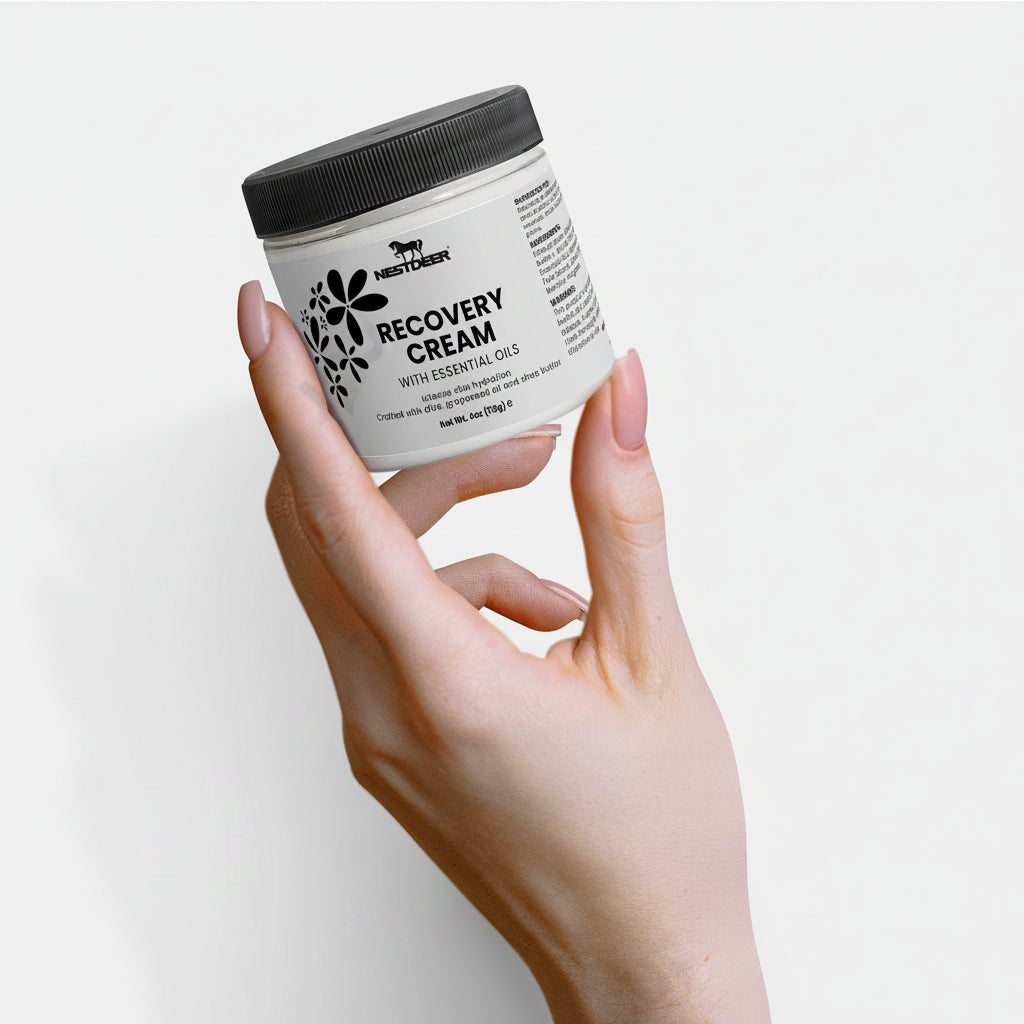 Hand holding a jar of Nestor Recovery Cream against a light background