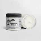 Jar of recovery cream with a black lid on a white background