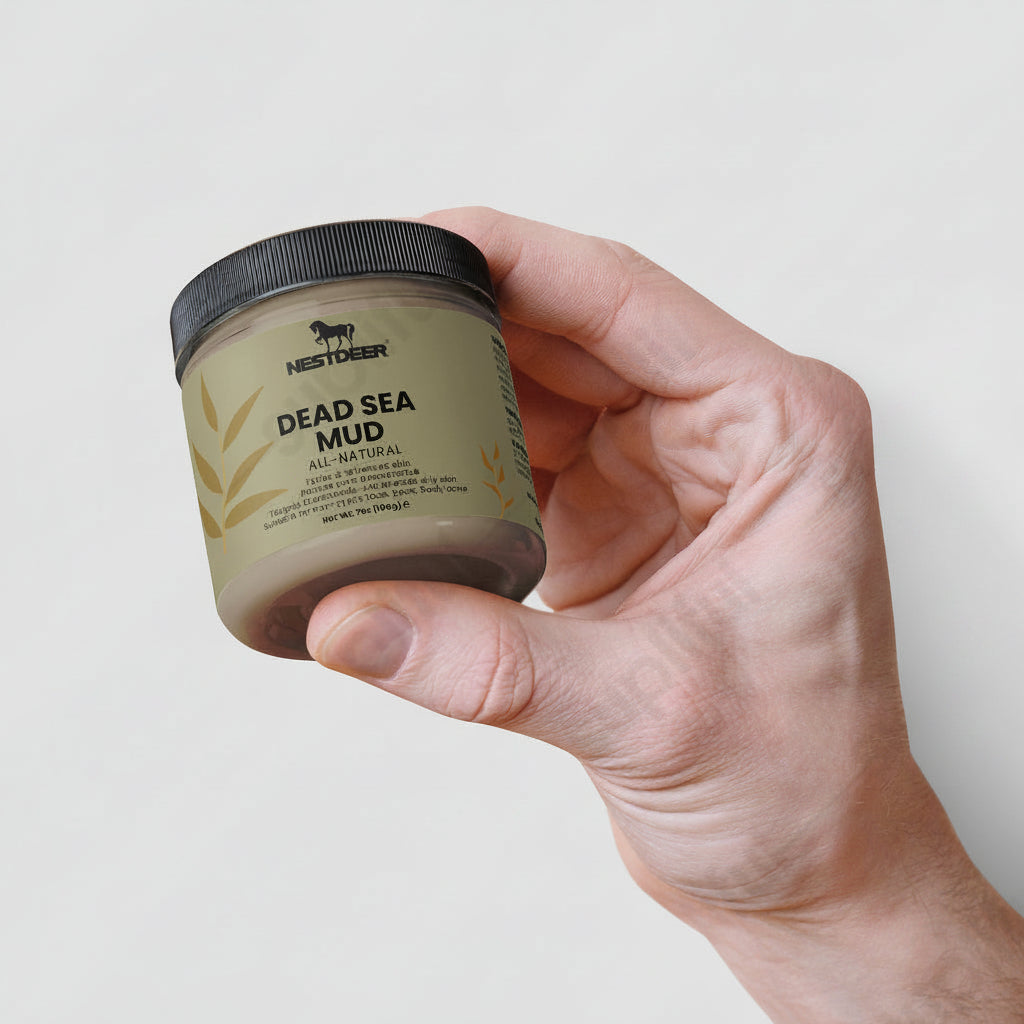 Hand holding a jar of Nestlé Deer Dead Sea Mud on a light gray background