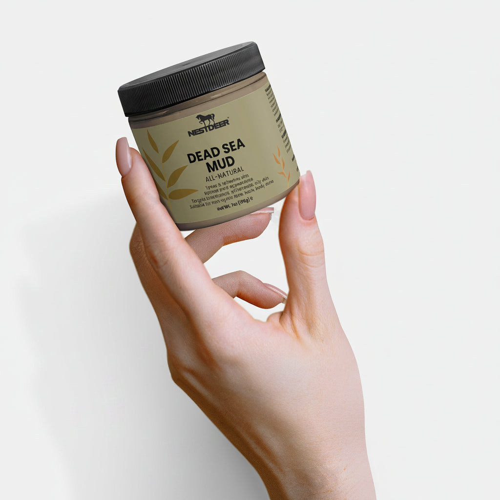 Hand holding a jar of Dead Sea Mud by Nestderm on a light background