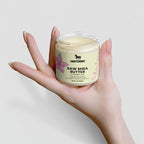 Hand holding a jar of Nestdeer Raw Shea Butter against a light background